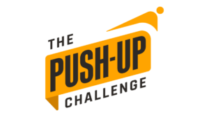 Logo of "The Push-Up Challenge" featuring bold text on an angular, yellow banner with a stylized figure in a push-up position above it.