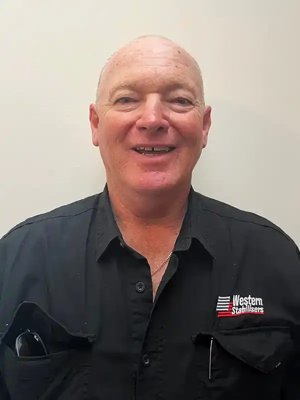 A smiling man with short hair wearing a black shirt with a "Western Stabilisers" logo, standing against a plain white background.